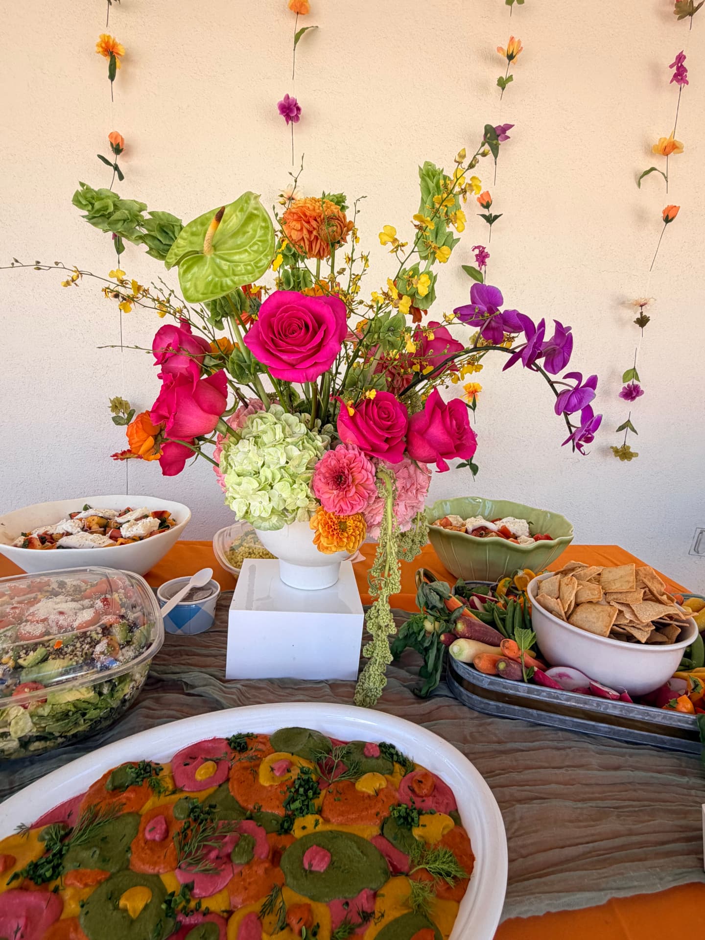 Statement party centerpiece with hot pink roses, green hydrangea, orchids and anthurium on a Santa Clarita event buffet table