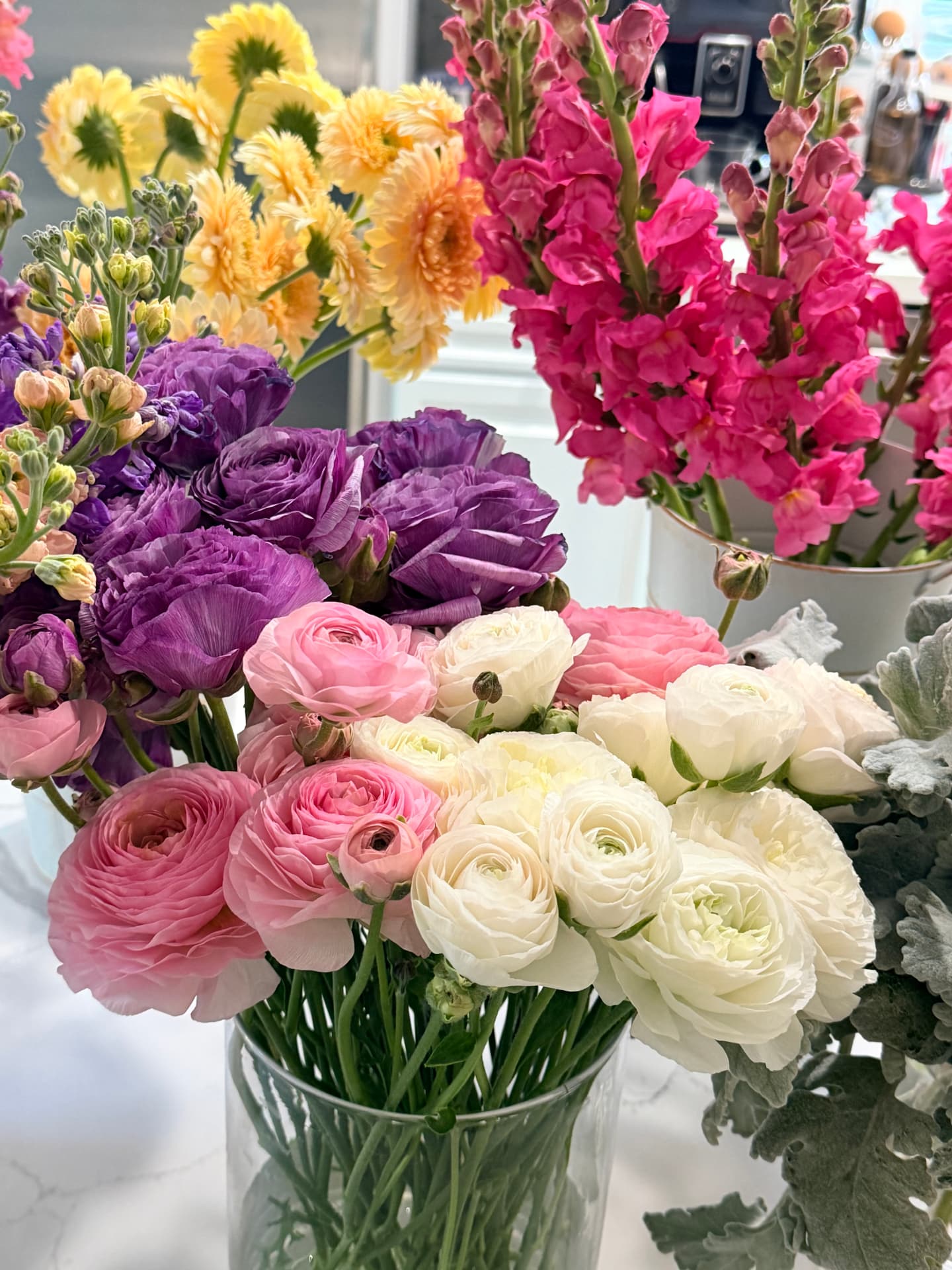 Purple ranunculus, pink garden roses, ivory blooms and magenta snapdragons ready for a build-your-own bouquet bar