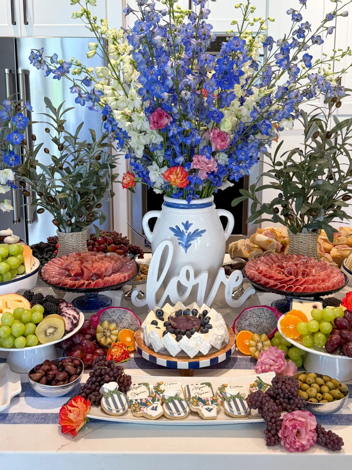 Blue and white flowers in a ceramic vase at a grazing table