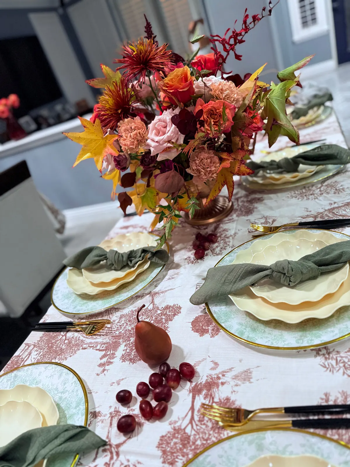 Autumn centerpiece with roses and leaves on a formally set dinner table