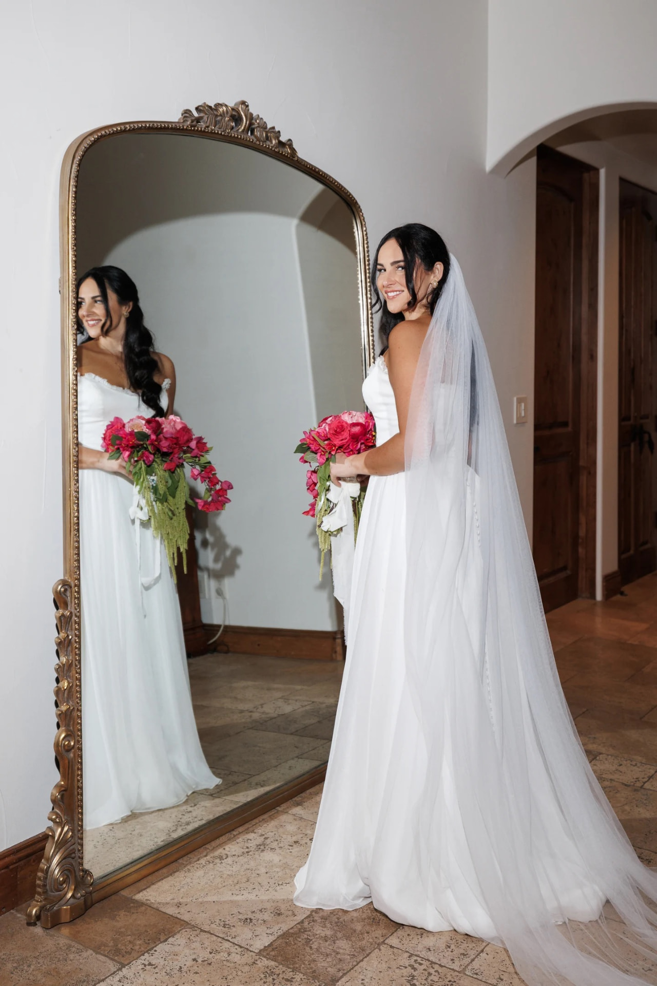 Bride holding a hot pink garden rose and bougainvillea cascading bridal bouquet designed by Bloom With Love