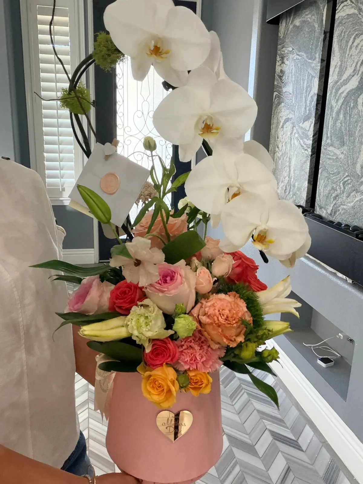 White orchids above multicolored roses in a blush keepsake box