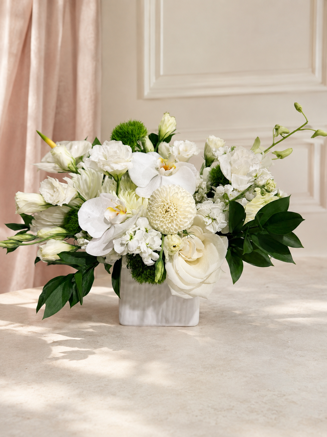 Ivory Garden Vase arrangement with white phalaenopsis orchids, white roses, dahlias and lisianthus in a ribbed white ceramic vase