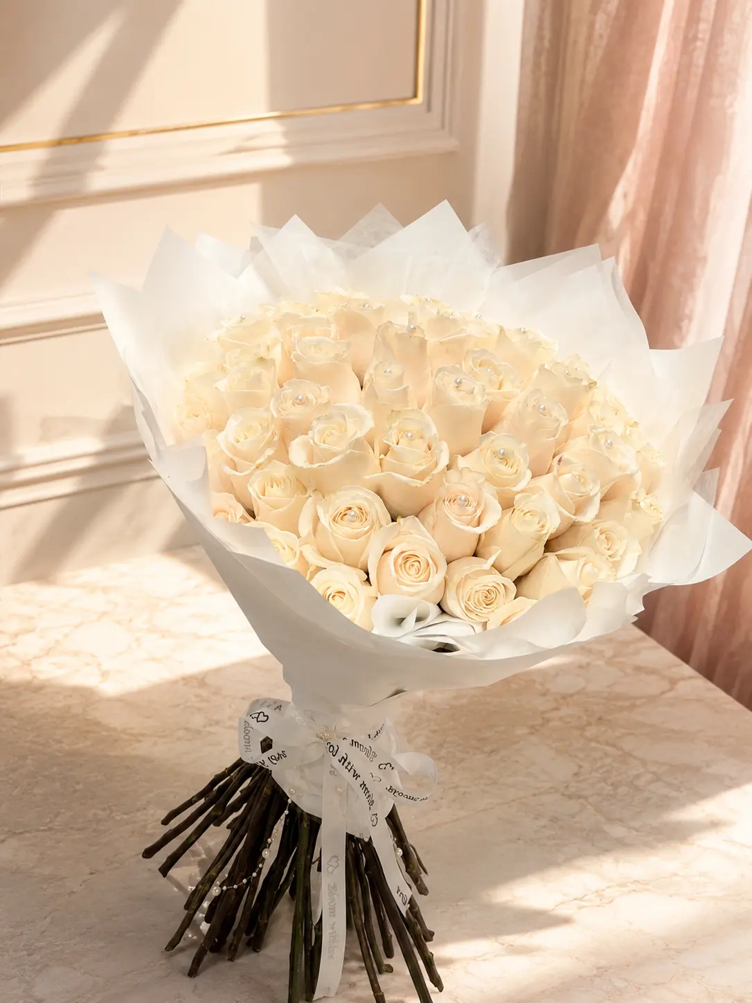 Ivory Pearl Rose Bouquet of luxurious ivory roses with pearl accents, wrapped in elegant white paper with a Bloom With Love ribbon