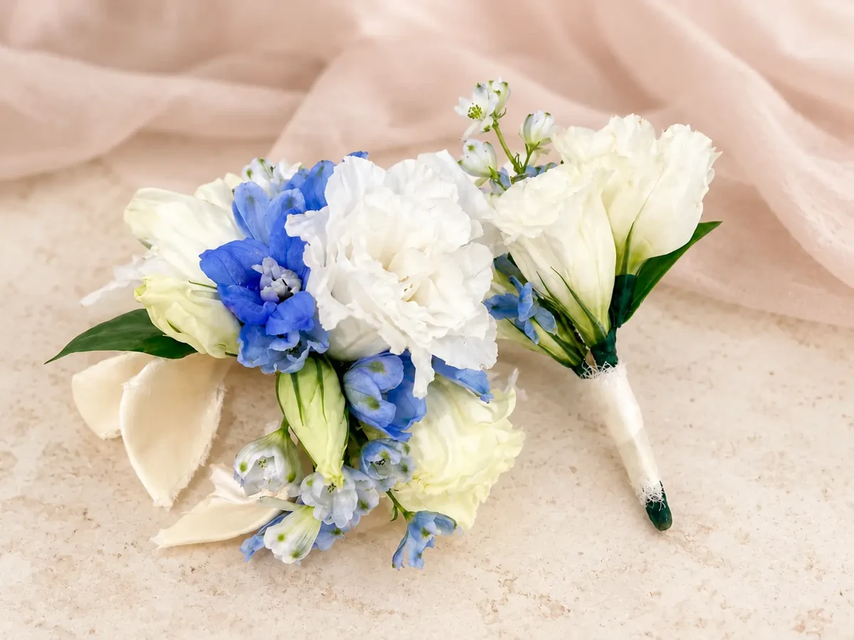 White and blue seasonal flower corsage with matching ivory boutonniere