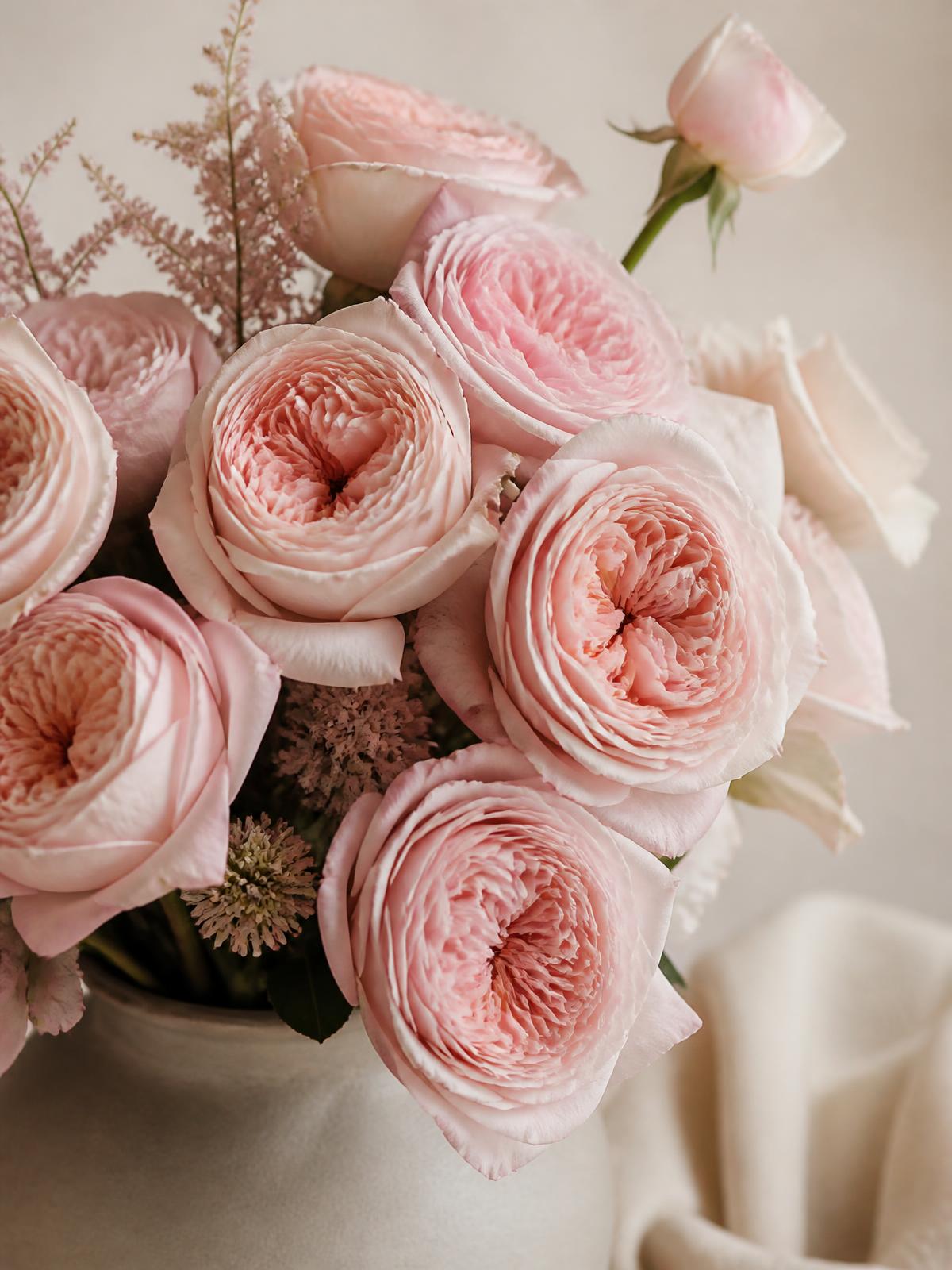 Blush garden roses and seasonal greenery arranged in a matte ceramic vessel at the Bloom With Love floral studio in Santa Clarita, CA
