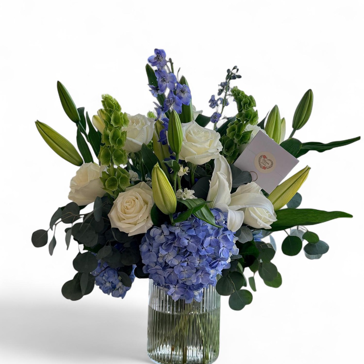 Luxury Garden arrangement with white roses, lilies, blue hydrangea and eucalyptus in a glass vase
